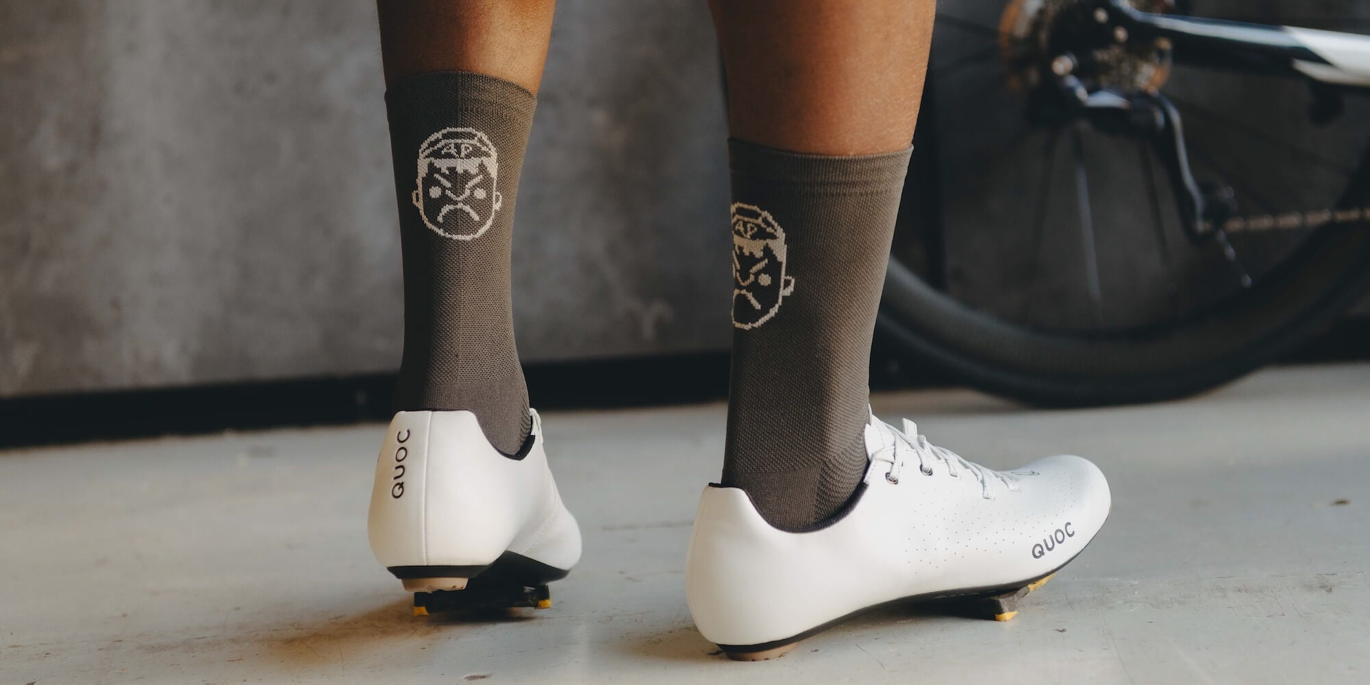 The back of the Angry Pablo grey cycling socks with face logo