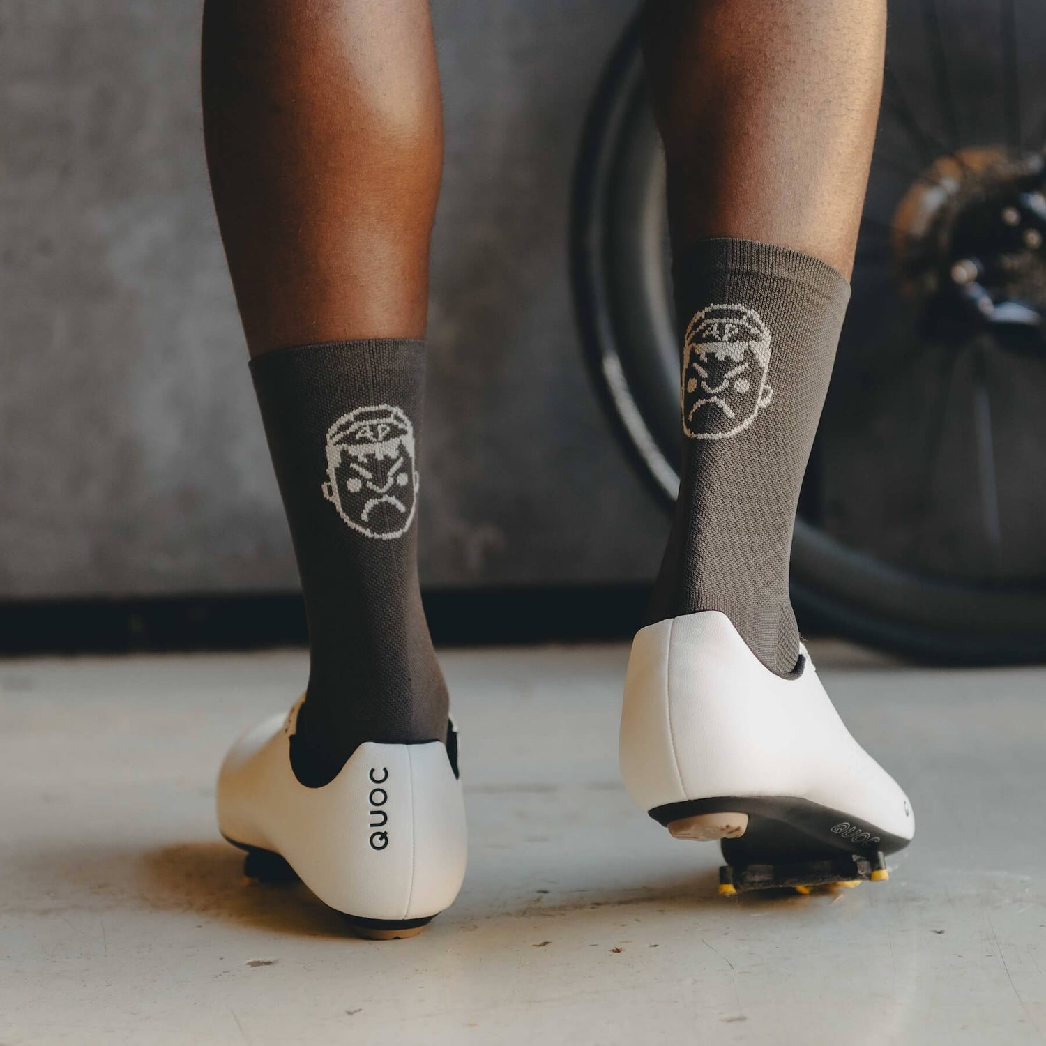The back of the Angry Pablo grey cycling socks showing the face logo stitching