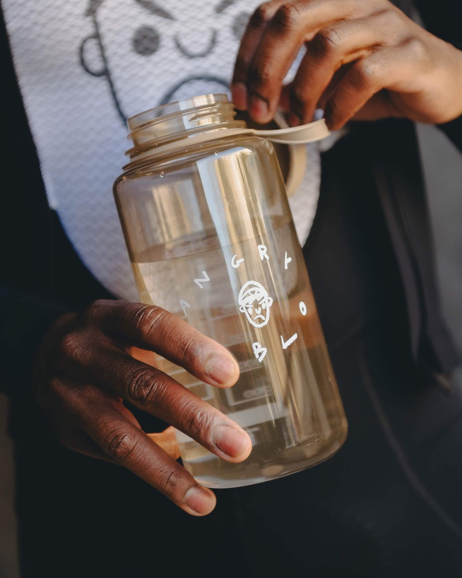 A cyclist holding an Angry Pablo Nalgene brown bottle