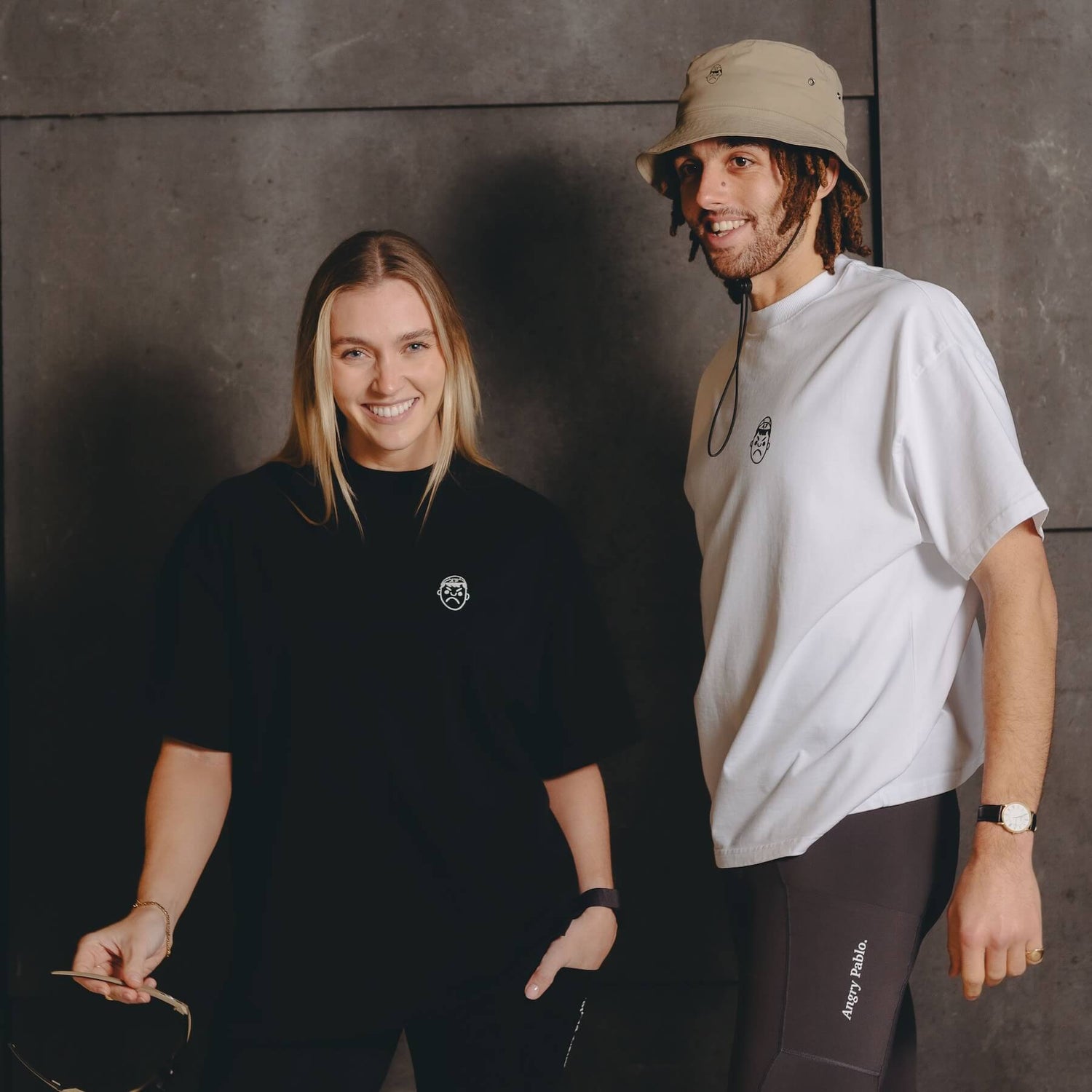 A male and female model wearing oversized t-shirts laughing